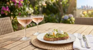 Chilled sparkling rosé glasses placed beside avocado toast and poached eggs at brunch.